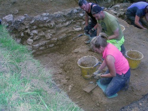 Volunteers uncovering the flagstone paving alongside one of the forecourt walls.