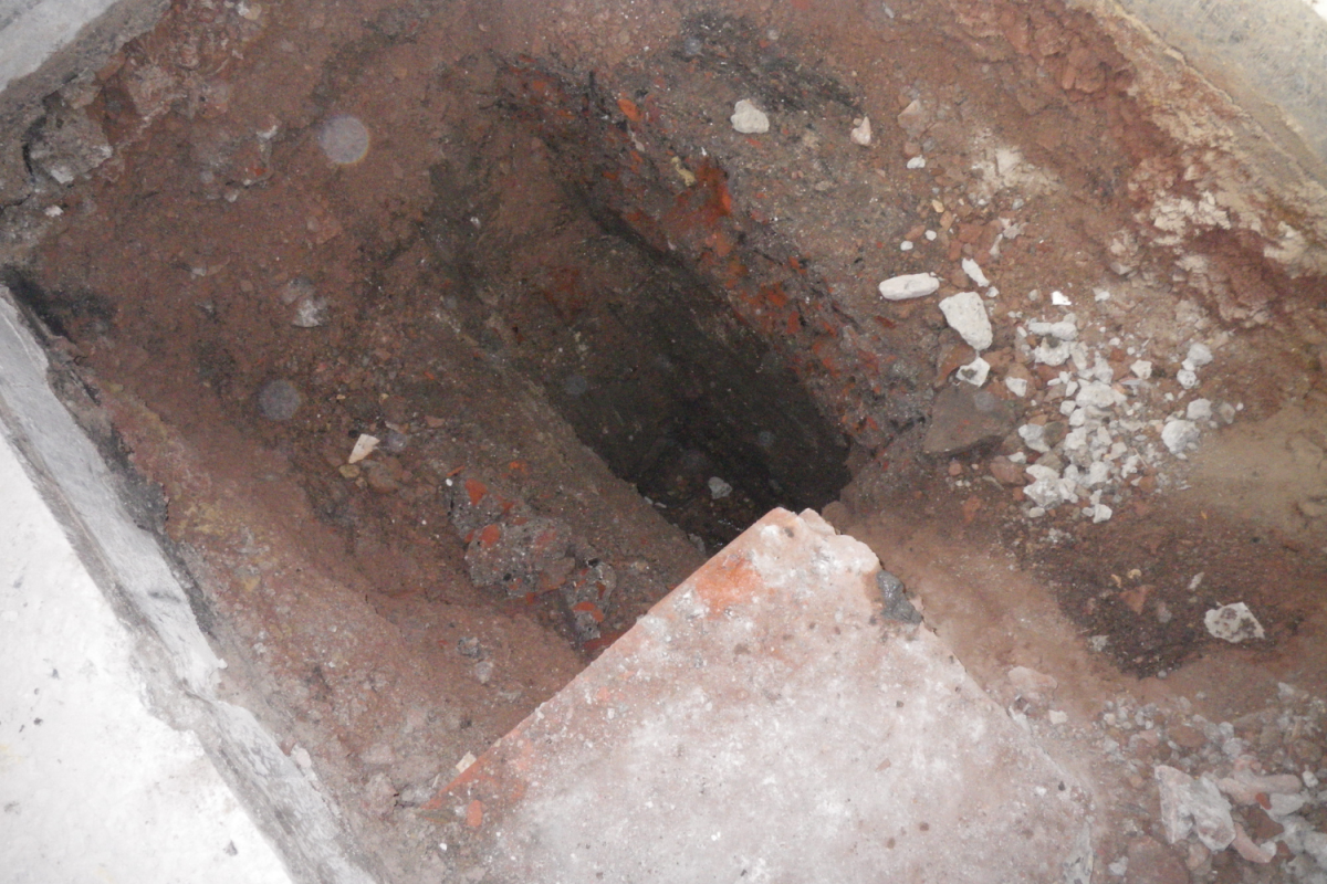 Test Pit 3 which contained human remains and shows the restricted conditions of excavation.