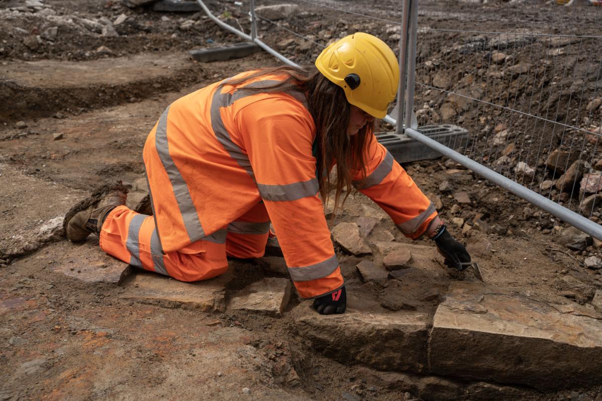 Archaeologist Isabelle excavates remains of the dressed sandstone drawbridge pier