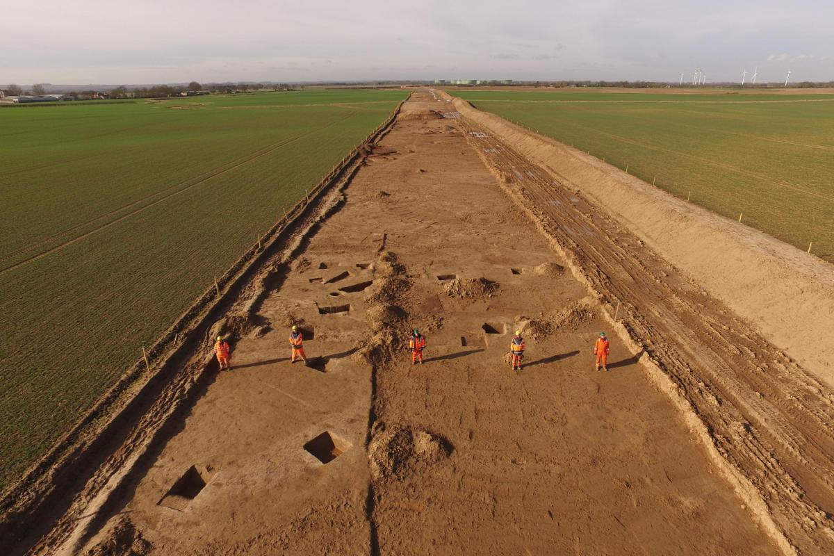 aerial view of archaeological trench in countryside with archaeologists