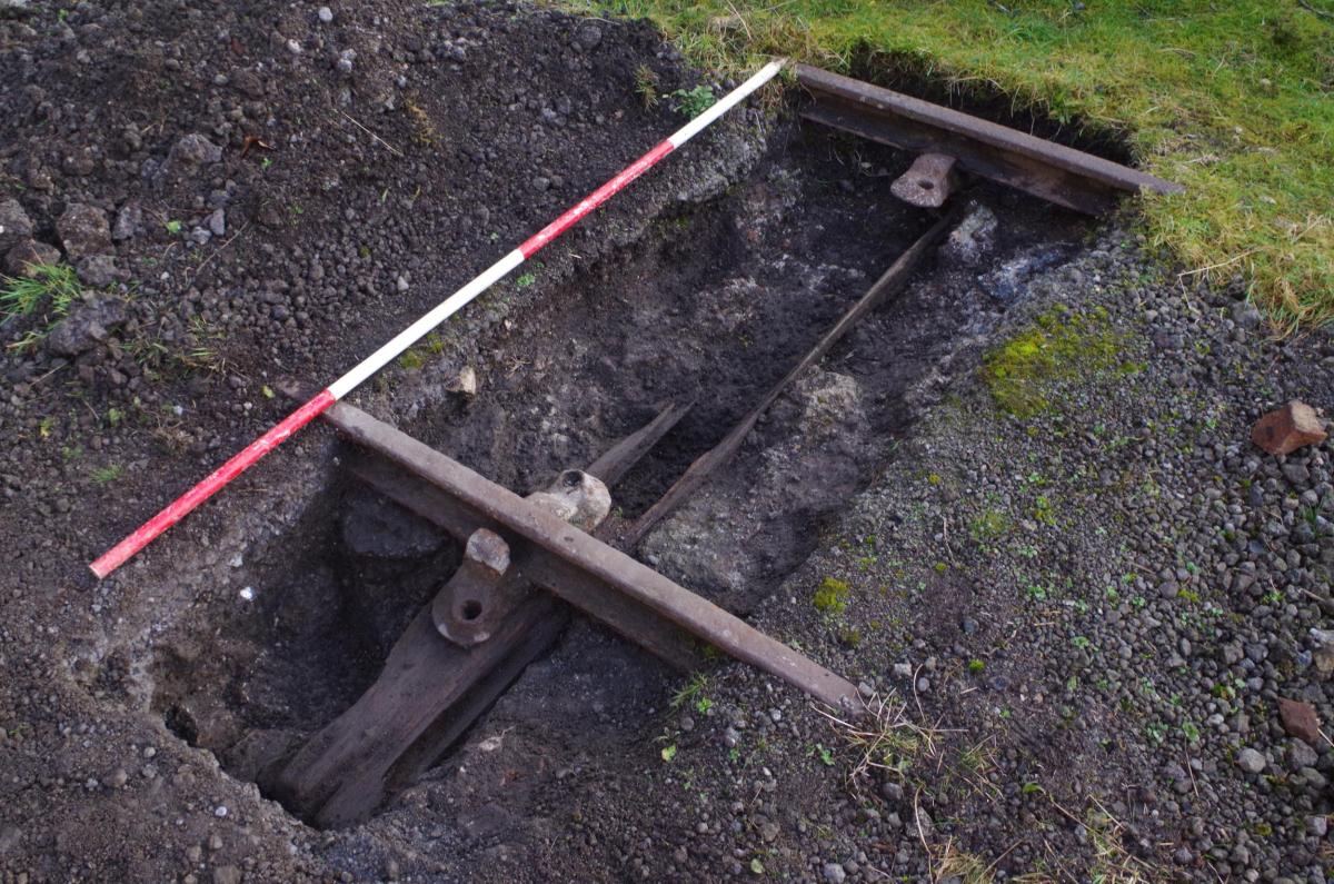 A test pit uncovering well-preserved metal rails and poorly preserved wooden sleepers