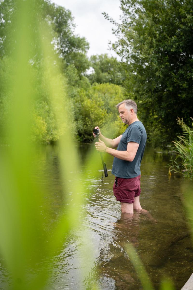 James Aldridge, Art practitioner on The Ripple Effect project, takes video footage using a GoPro whilst stood in the River Avon