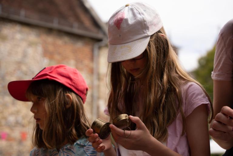 A young child examines an artefact from a recent excavation. 